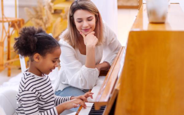 Little girl and her piano teacher in studio