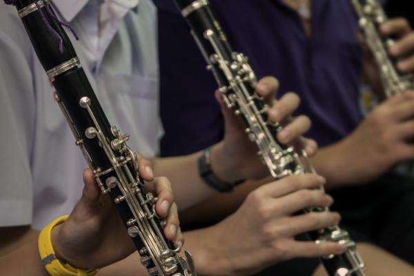 Closeup of 3 clarinetists' hands playing