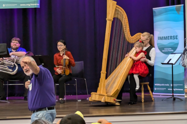 Harpist working with little girl at IMMERSE event