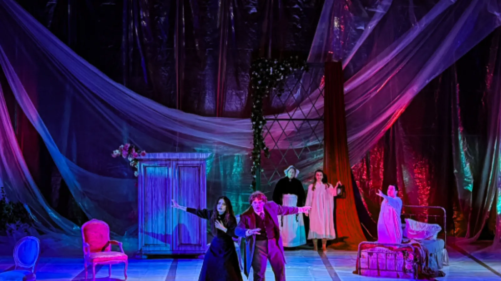 Opera stage decorated with furniture, drapery and dark eerie lighting