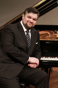 Luiz Guilherme Pozzi sitting at a grand piano