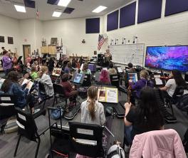 Students in seats with instruments during middle school orchestra class