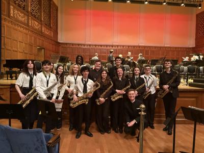 School of Music students, Liberty HS students, and Dr. Scott Jones posing with instruments