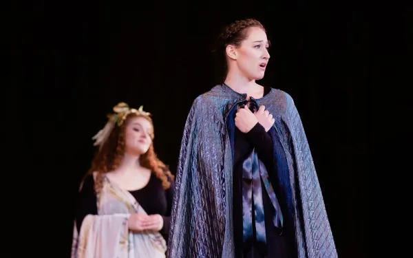 Two singers in costume on stage