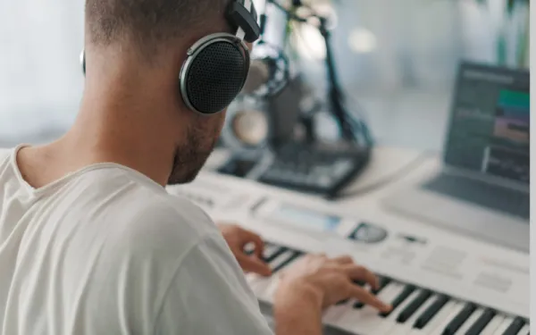 Guy at keyboard with headphones and computer