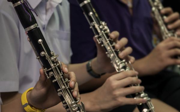 Closeup of 3 clarinetists' hands playing