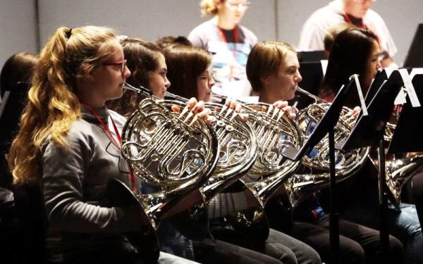 French horn section players performing