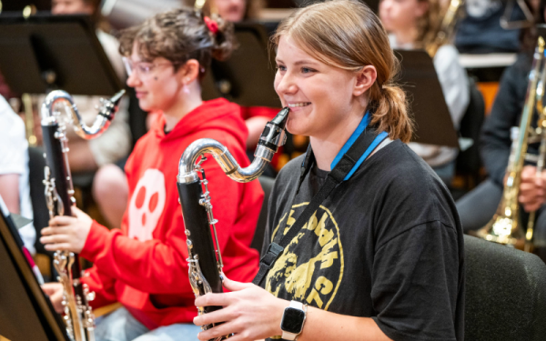 Two female students smiling in band rehearsal