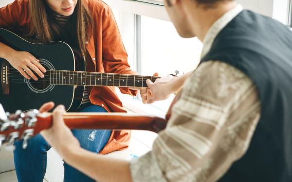 Guy and girl playing guitar