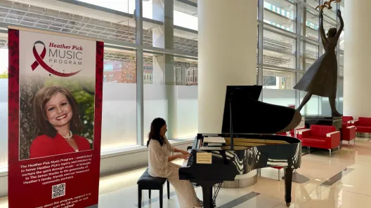Pianist in white gown playing grand piano