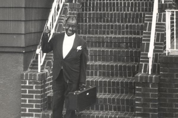 Louis Armstrong on front steps of his home
