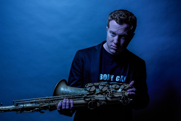 Guest Artist Adam Larson holding his saxophone