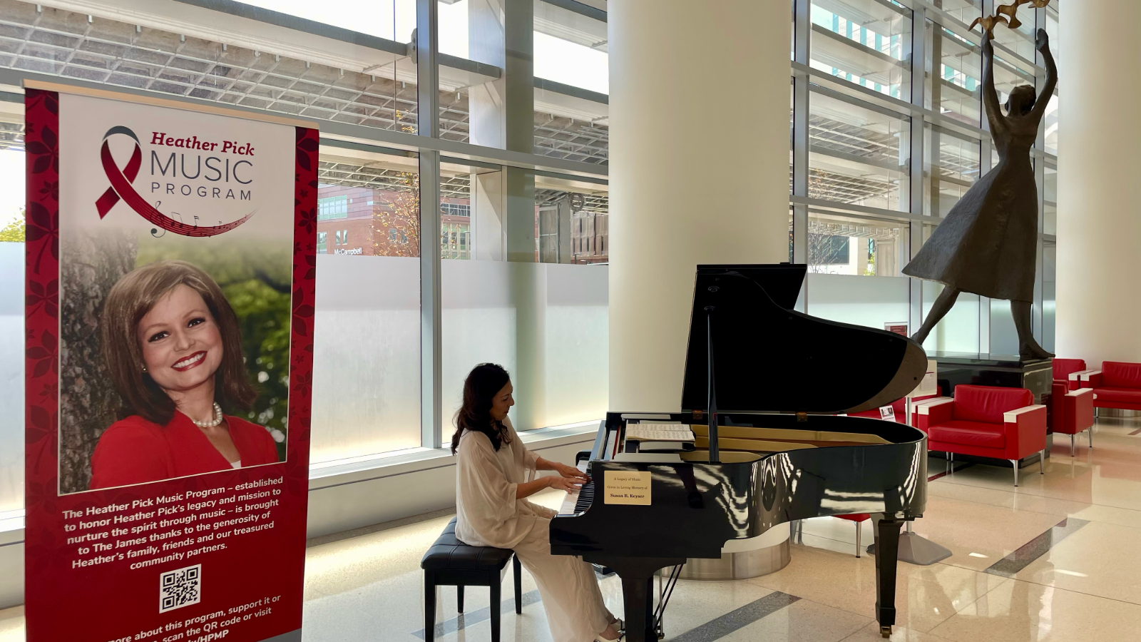 Pianist in white gown playing grand piano