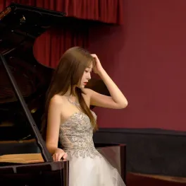 Picture of piano teacher standing in front of piano