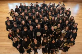 Band standing in a tight circle looking at at camera